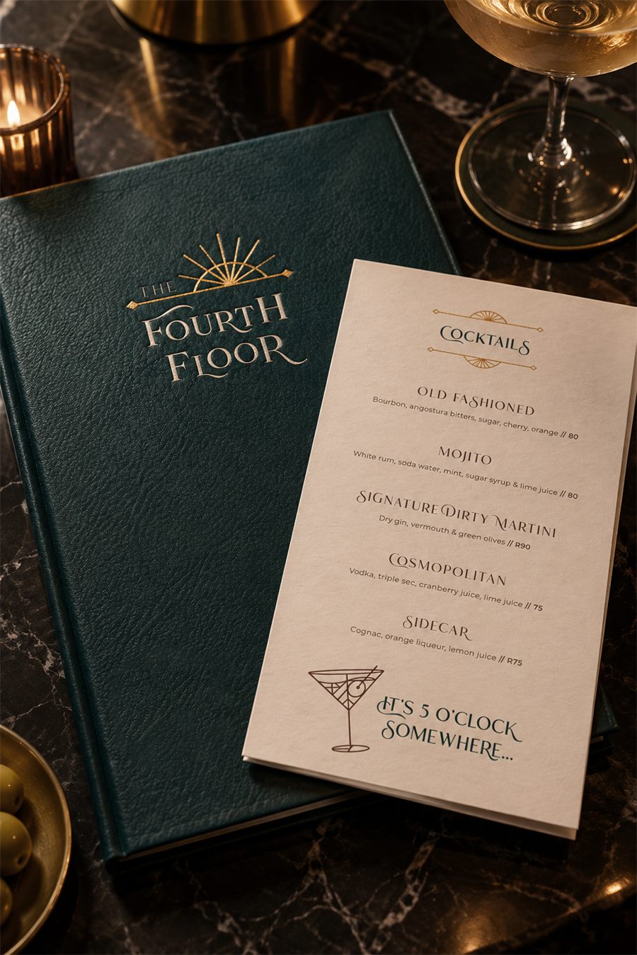 The Fourth Floor cocktail menu design: green leather menu with gold foil logo and a card on a marble bar